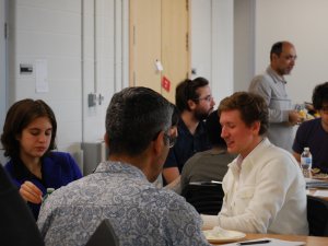 QuSoft attendees sitting at tables talking to one another.