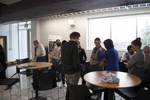 QuSoft attendees clustered in groups and talking to one another.