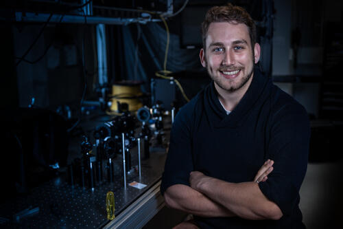 Andrew Cameron wearing a black shirt with his arms crossed and smiling